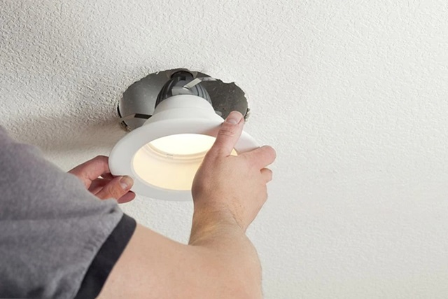 a person fixing a lighting